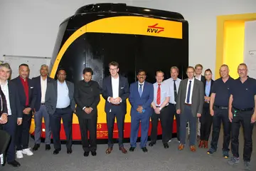 Die Delegation aus Indien und Vertreter*innen der VBK und AVG stehen vor einem Fahrsimulator, den die beiden Verkehrsunternemen beid er Ausbildung von neuem Fahrpersonal für ihre Tram- und Stadtbahnen einsetzten.