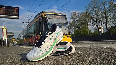 Laufschuhe vor einer VBK-Bahn.