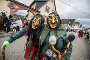 Mitgleider einer Fastnachtsgruppe ziehen maskiert durch Hörden