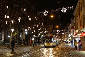 Eine Tram der Linie 1 fährt durch das weihnachtlich beleuchtete Durlach. 
