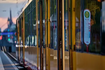 Seitliche Ansicht einer AVG-Stadtbahn mit geöffneten Türen.