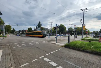 Eine Trambahn der Linie 2 passiert den Kreuzungsbereich Siemensallee/Neureuter Straße/B36. Autos stehen an Ampeln. Der Himmel ist bewölkt.