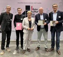 Das Foto zeigt Matthias Schmidt (1.v.r.) und Frank  Nenninger (2.v.r.) von der Karlsruher Schieneninfrastruktur Gesellschaft (KASIG), Landesbauministerin Nicole Razavi (Mitte), Prof. Ludwig Wappner (1.v.l.) und Vasko Petkov (2.v.l) vom Architekturbüro allmannwappner bei der Verleihung des Staatspreises Baukultur. 