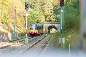 Eine AVG der Stadtbahnlinie S4 fährt aus einem Tunnel. 