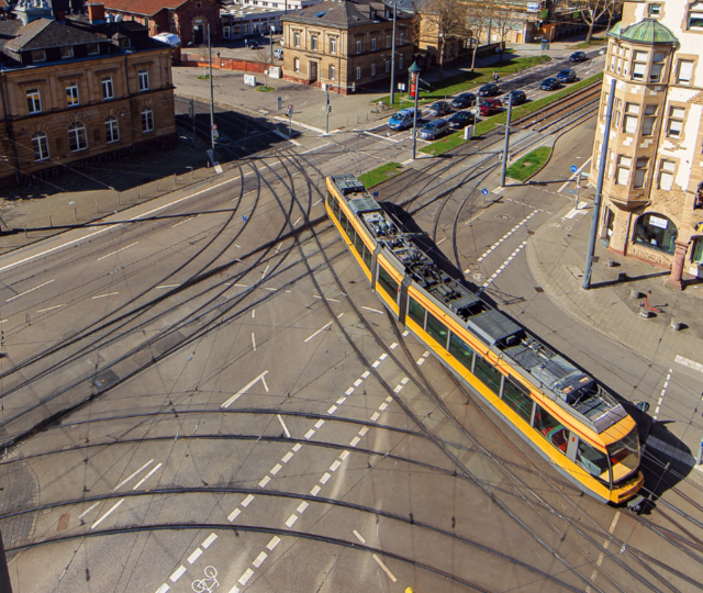Sicht von oben auf die Kreuzung Durlacher Allee/Tullastraße. Eine gelbe Straßenbahn fährt über die Kreuzung.