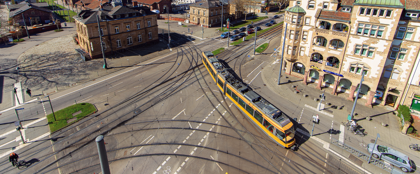Sicht von oben auf die Kreuzung Durlacher Allee/Tullastraße. Eine gelbe Straßenbahn fährt über die Kreuzung.