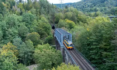 AVG-Stadtbahn fährt auf einer Brücke im Murgtal.