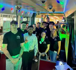 In einer bunt beleuchteten Bahn steht das VBK- und AVG-Team, das die Karaoke-Bahn organisiert hat. 