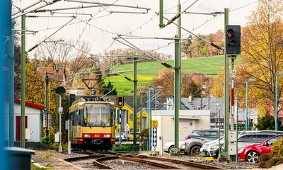 AVG-Stadtbahn fährt durch Ortschaft.