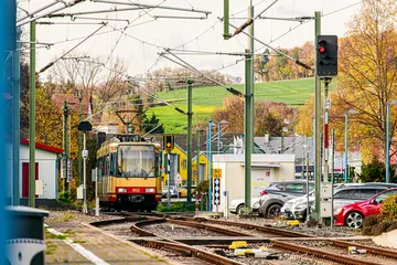 AVG-Stadtbahn fährt durch Ortschaft.