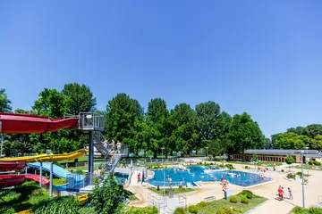 Blick auf das Rheinstrandbad Rappenwört mit Schwimmbecken und Rutsche.