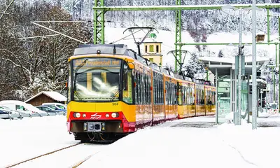 Die S8 fährt auf der verschneiten Gäubahnstrecke.