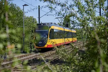 Eine AVG-Bahn der Linie 4 fährt auf Schienen. 