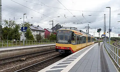 Ansicht einer Bahn in den Rastatter Bahnhof einfährt.