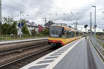 Ansicht einer Bahn in den Rastatter Bahnhof einfährt.