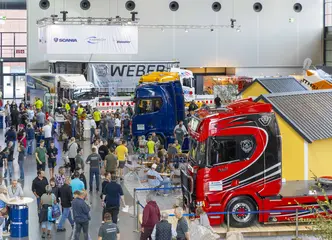 Das Foto zeigt Besucher*innen und ausgestellte Fahrzeuge bei der Nutzfahrzeugmesse NUFAM.