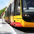 Zwei Frauen steigen in die Straßenbahn ein, eine von ihnen steigt mit einer Gehhilfe ein. 