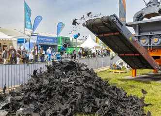 Eine Maschine zerhäckselt Altreifen auf der Messe zu Demonstrationszwecken. 