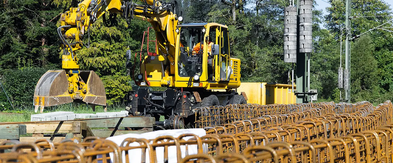 Bauarbeiten im Gleis. Ein Bagger arbeitet an einem Bahnsteig.