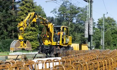 Bauarbeiten im Gleis. Ein Bagger arbeitet an einem Bahnsteig.