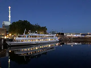 MS Karlsruhe-Schiff auf dem Rhein am Hafen mit vielen Menschen am Steg.