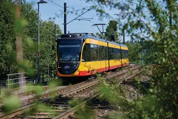 AVG-Stadtbahn fährt auf Gleisen im Umland. 