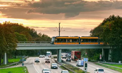 Eine Bahn der Linie S1 fährt über eine Brücke. Darunter liegt die Karlsruher Südtangente. 