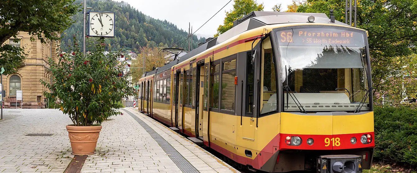 Eine AVG-Stadtbahn steht an der Haltestelle Bad Wildbad Kurpark mit geöffneten Türen. 