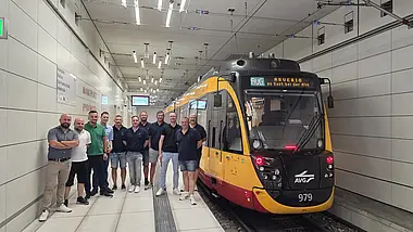 Die Delegation von Arverio steht an der Haltestelle Marktplatz im Karlsruher Stadtbahntunnel neben einer Stadtbahn der Albtal-Verkehrs-Gesellschaft