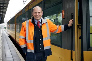 Jochen Dietz steht neben einer AVG-Stadtbahn