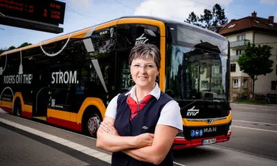 Eine Busfahrerin der VBK steht vor dem modernen Elektrobus.