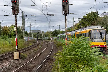 Seitliche Ansicht einer AVG-Stadtbahn, die auf Gleisen fährt.