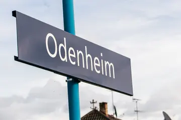 Blaues Haltestellenschild mit der weißen Aufschrift "Odenheim"