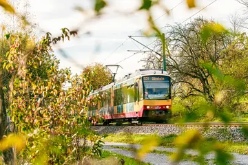 AVG-Stadtbahn fährt durch Landschaft.