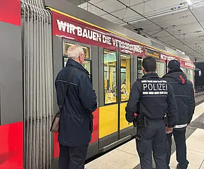 Polizei und BIG-Fahrscheinprüfer stehen vor einer VBK-Tram im Stadtbahntunnel.