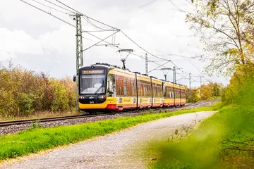 Eine Bahn der AVG-Linie S1 fährt auf Schienen. 