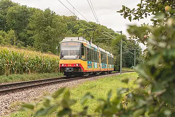 Seitliche Ansicht der AVG-Stadtbahn auf Gleisen.