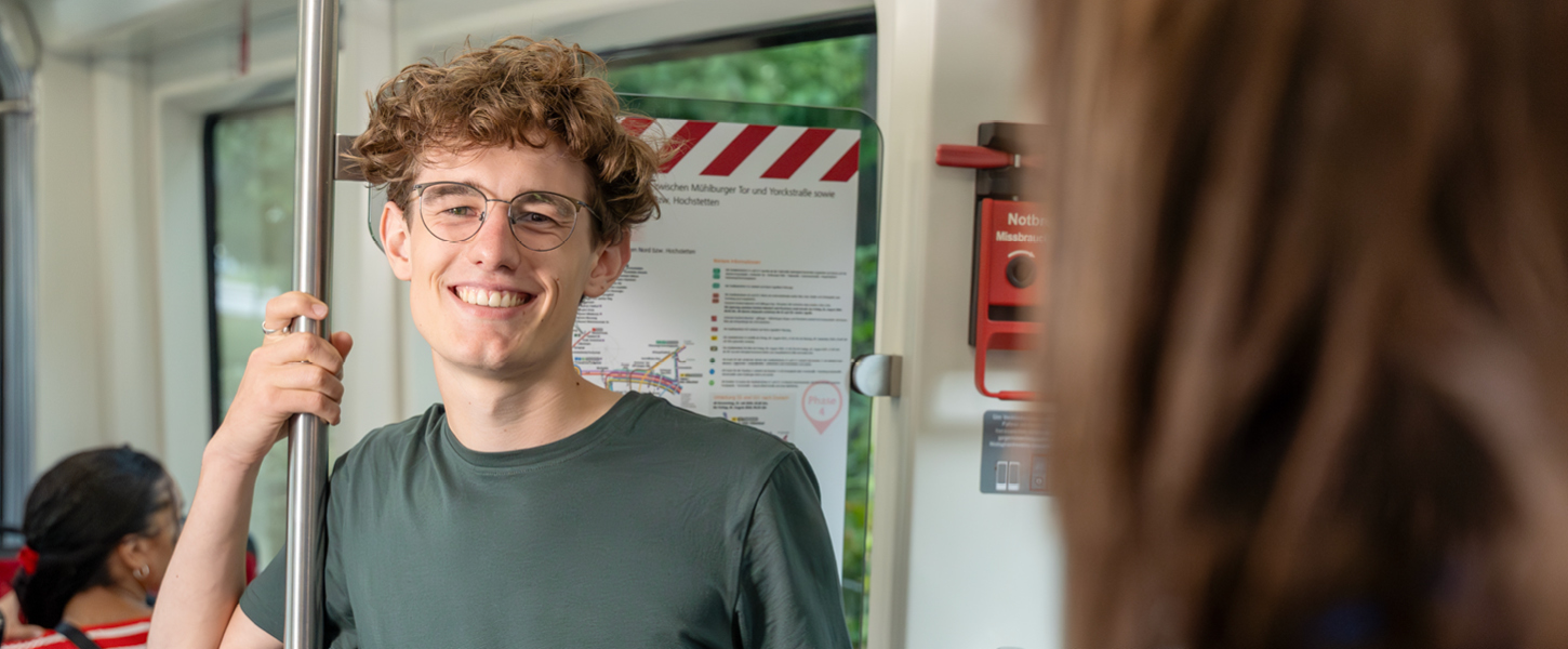 Ein junger Mann steht in der Bahn.